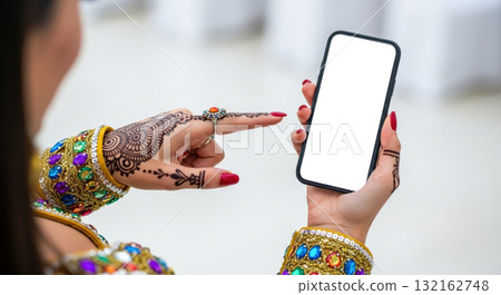 Woman with henna mehndi tattoo on hands holding smartphone with blank white screen, indian tradition and modern technology concept, wedding mockup 132162748