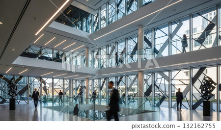 Modern corporate office interior with business people in spacious sunlit lobby, contemporary architecture with large glass windows and multi level design Modern corporate office interior with business people in spacious sunlit lobby, contemporary architecture with large glass windows and multi level design 132162755