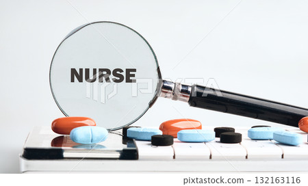 A nurses essentials lay on a clean surface, featuring colorful pills and a magnifying glass displaying the word NURSE, emphasizing their vital role in patient care 132163116