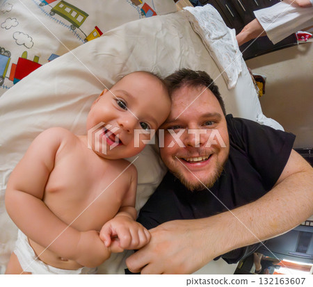 Father and Baby Smiling on Bed 132163607