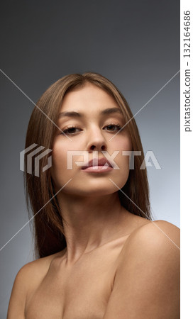 Portrait of young woman with natural skin and confident gaze in beauty concept Portrait of young woman with natural skin and confident gaze in beauty concept 132164686