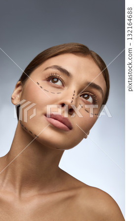 Woman with surgery markings looking upward with gentle hope and self-confidence Woman with surgery markings looking upward with gentle hope and self-confidence 132164688