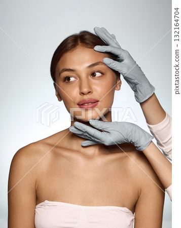 Doctor in gloves touching woman face with gentle care and patient confidence during consultation Doctor in gloves touching woman face with gentle care and patient confidence during consultation 132164704