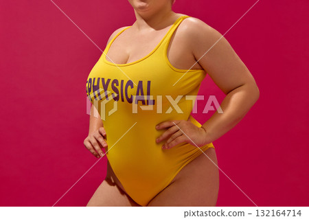 Close-up fashion shot of woman in yellow swimsuit showing curves and modern elegance 132164714