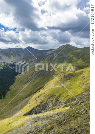 Green mountain slopes and valley with cloudy sky in French Alps 132164917