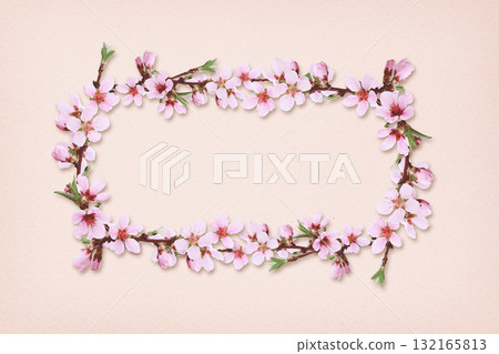 Spring peach twigs in a floral frame on pink paper background. Spring peach twigs in a floral frame on pink paper background. 132165813