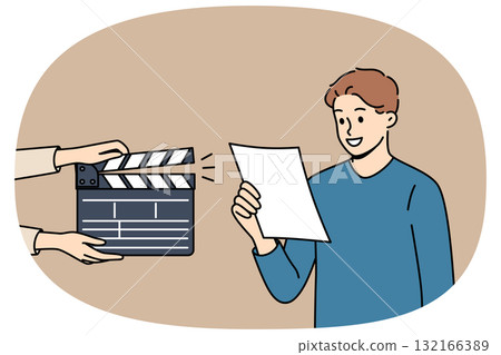Man actor participates in casting, reading text from piece of paper, standing near clapperboard 132166389