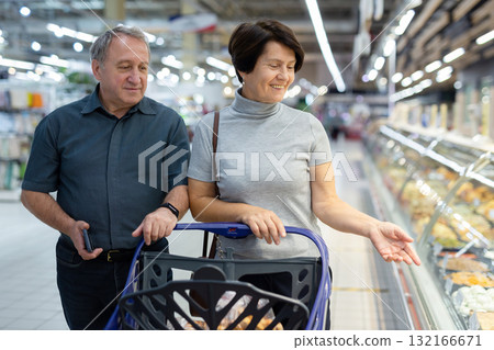 elderly couple walks through a supermarket 132166671