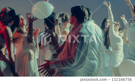 Young people dancing freely with balloons at white Valentine night 132166756