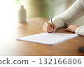 Woman hand signing paper form or contract on table 132166806