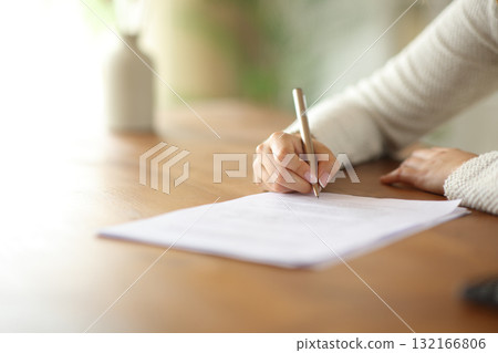 Woman hand signing paper form or contract on table 132166806