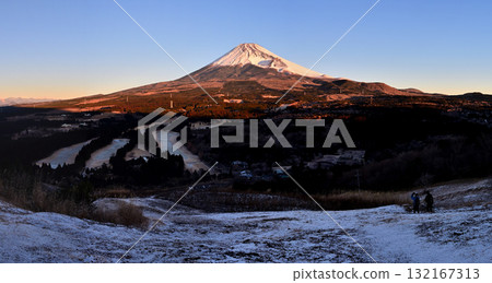 從十里木高原展望台拍攝的白雪皚皚的相鷹山脈的越前山和沐浴在晨曦中的富士山的全景照片 132167313