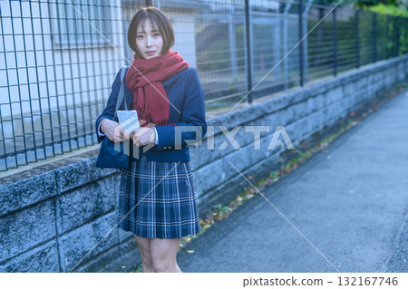 High school girls going to and from school for club activities on a cold day; high school students wearing winter clothes and carrying hand warmers; going to and from school 132167746