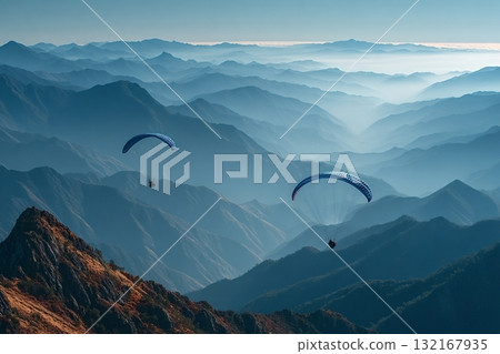 Paragliders flying over majestic mountain range at sunset 132167935
