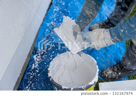 Worker applying renovation plastering stucco to exterior wall Worker applying renovation plastering stucco to exterior wall 132167974