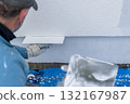 Worker plastering wall with stucco during renovation project 132167987