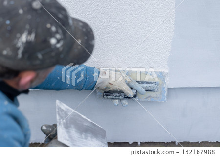 Worker applying stucco plaster on building wall exterior Worker applying stucco plaster on building wall exterior 132167988