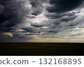 Dark clouds drift away as light fades in late evening sky 132168895