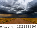 Dark storm clouds over a dusty country road 132168896
