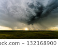 Heavy rain bands clear to reveal setting sun colors below stormy sky 132168900