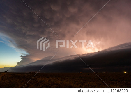 Lightning flickering through approaching storm clouds 132168903