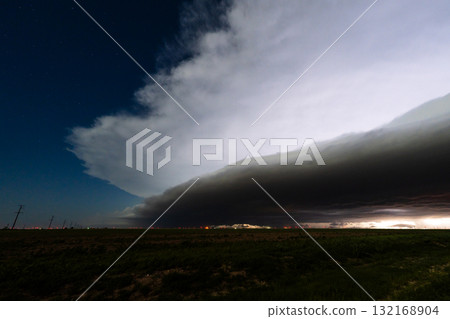 Lightning Lurks Beneath Churning Clouds Above a Silent Countryside 132168904