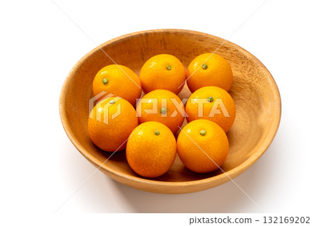 Fresh kumquats in a wooden bowl Fresh kumquats in a wooden bowl 132169202