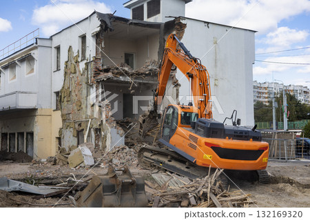 Heavy machinery demolishes building structure during construction project in urban area Heavy machinery demolishes building structure during construction project in urban area 132169320