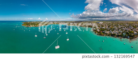 Aerial view of Grand Baie Mauritius with moored sailboats calm lagoon coastal neighborhoods and billowing afternoon clouds Aerial view of Grand Baie Mauritius with moored sailboats calm lagoon coastal neighborhoods and billowing afternoon clouds 132169547