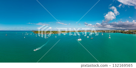 North Coast, Mauritius sweeping aerial seascape of moored yachts turquoise lagoon gentle waves and low tropical urban coastline North Coast, Mauritius sweeping aerial seascape of moored yachts turquoise lagoon gentle waves and low tropical urban coastline 132169565