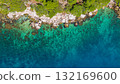 Rocky Dalmatian shore in Croatia with crystal water reef patterns and dense pine canopy viewed directly from above 132169600