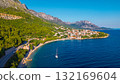 Mediterranean hillside settlement overlooking turquoise coves on Makarska Riviera Croatia captured from above during golden hour 132169604