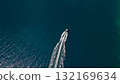 Top down drone of speedboat carving clean wake across teal sea near rocky coast minimal copyspace background 132169634