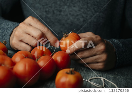 closeup of a man sewing Spanish tomates de colgar closeup of a man sewing Spanish tomates de colgar 132170266