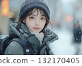 Beautiful young woman in winter clothes in the snow 132170405