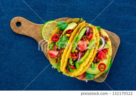 Tacos on a wooden board, Mexican food, overhead flat lay shot on blue Tacos on a wooden board, Mexican food, overhead flat lay shot on blue 132170522