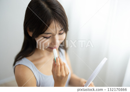 Young woman applying lip balm Young woman applying lip balm 132170866