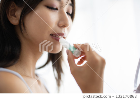 Young woman applying lip balm Young woman applying lip balm 132170868