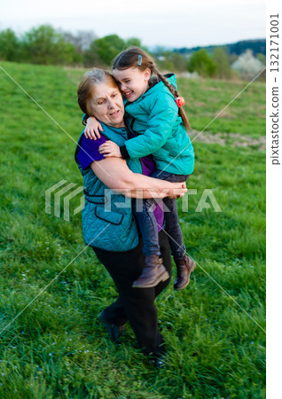 Grandmother and granddaughter sharing a joyful moment outdoors. Grandmother and granddaughter sharing a joyful moment outdoors. 132171001
