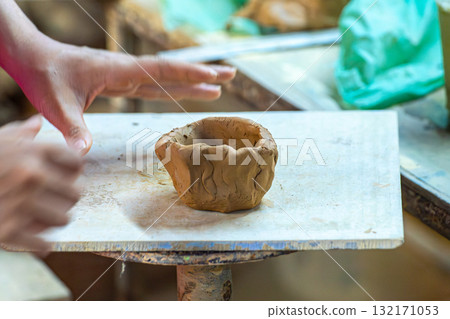 Hand shaping clay pottery in workshop Hand shaping clay pottery in workshop 132171053