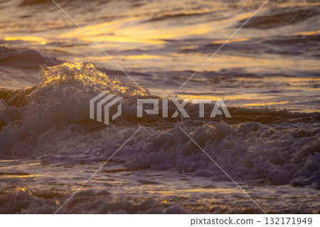 Golden Waves at Sunset A breathtaking view of the ocean during the stunning evening light Golden Waves at Sunset A breathtaking view of the ocean during the stunning evening light 132171949