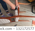 Anonymous person restore old vintage chair in home. Fabric replacement. Antique furniture and modern striped linen and cotton fabric. Hobbies, crafts, and retro-minimalist style. 132172577