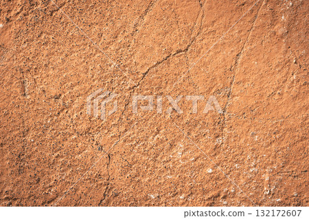 Orange-brown concrete wall texture. Rough stone texture. Stone background. Cracked paint and poster. Orange-brown concrete wall texture. Rough stone texture. Stone background. Cracked paint and poster. 132172607