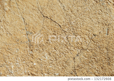 Orange-brown concrete wall texture. Rough stone texture. Stone background. Cracked paint and poster. 132172608