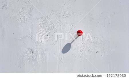 Minimal red pushpin on textured white wall with long shadow and copy space Minimal red pushpin on textured white wall with long shadow and copy space 132172980
