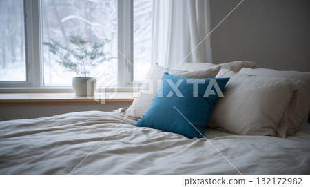 Cozy bedroom with blue pillow and soft winter window light 132172982