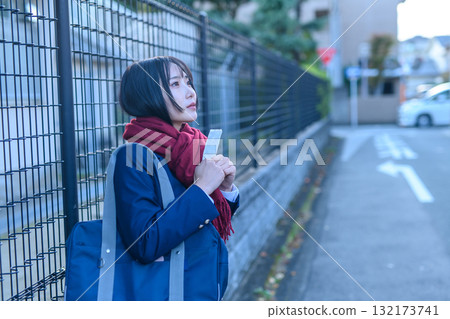在寒冷的日子裡，高中女生去學校參加俱樂部活動；穿著冬裝的高中生拿著暖手寶等待朋友；去學校 132173741