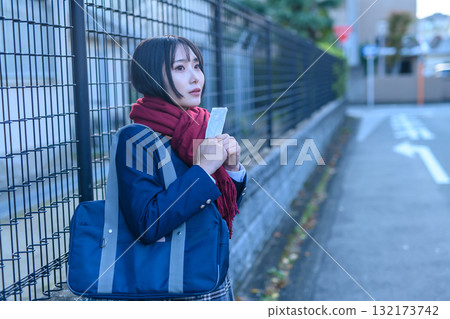 High school girls going to and from school for club activities on a cold day; high school students in winter clothes holding hand warmers and waiting for friends; going to and from school 132173742