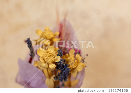 Dried flower bouquet with yellow and purple flowers. A close-up shot of a bouquet of dried flowers wrapped in purple paper 132174166
