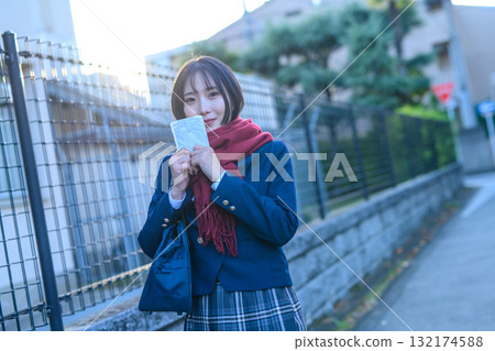 寒冷天氣裡，女高中生們到學校參加社團活動，穿著冬裝、戴著暖手寶上學。 132174588